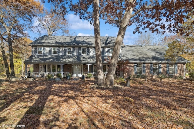 view of front of home featuring covered porch and brick siding