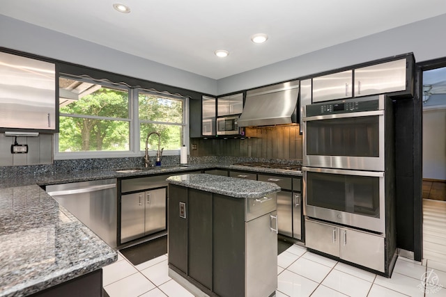 14930 W Wadsworth Rd, Wadsworth, IL 60083 - kitchen with stainless steel appliances, exhaust hood, a kitchen island, light tile patterned floors, and dark stone countertops