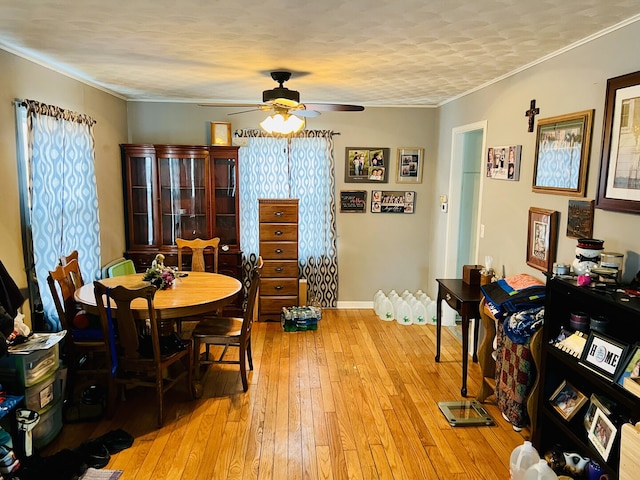 dining space featuring light wood-style floors, ceiling fan, ornamental molding, and baseboards