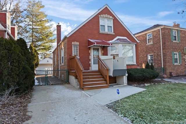 view of front of house featuring a garage, a chimney, a gate, fence, and brick siding