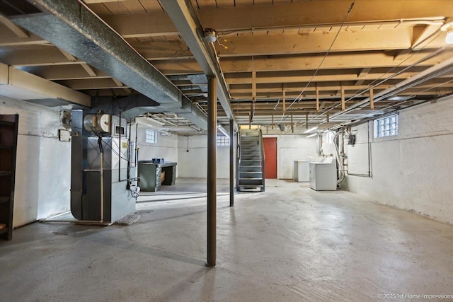 basement with heating unit, stairway, and washer / clothes dryer