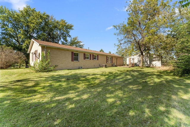 exterior space featuring crawl space, a lawn, and brick siding