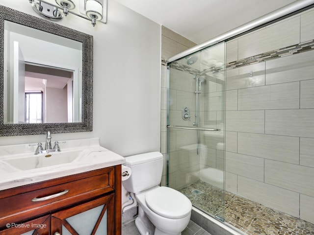 full bath featuring toilet, a shower stall, and vanity