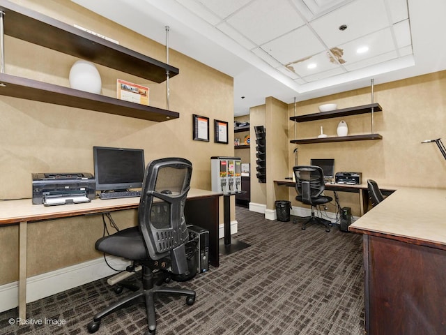 office space with dark colored carpet, recessed lighting, a raised ceiling, and baseboards