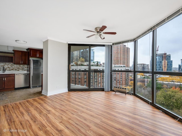 unfurnished sunroom featuring a view of city and a sink