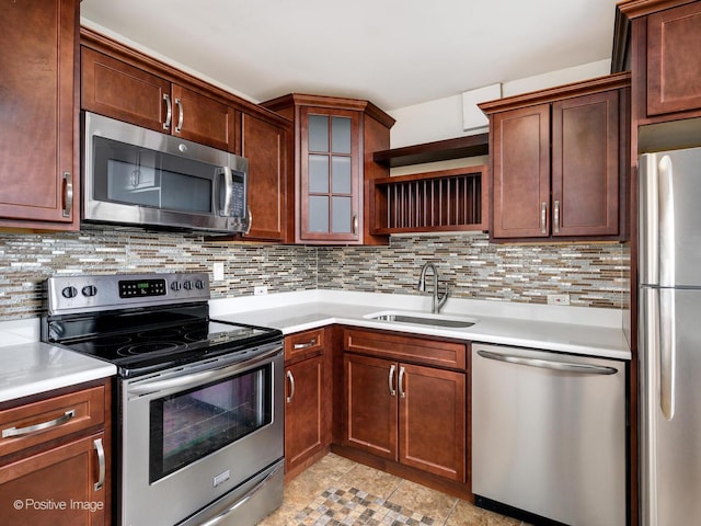 kitchen with stainless steel appliances, a sink, light countertops, decorative backsplash, and open shelves