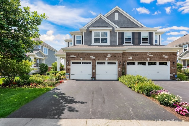 view of front of house featuring a garage, aphalt driveway, and brick siding