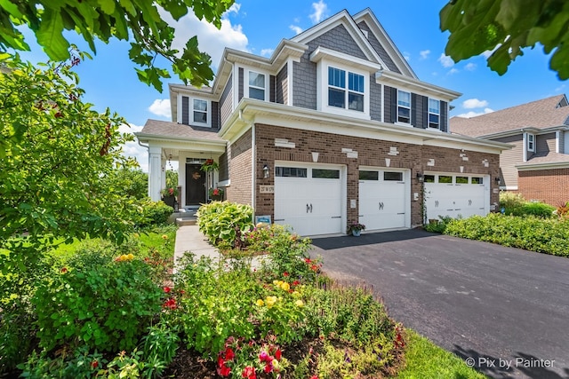 view of front of property featuring an attached garage, aphalt driveway, and brick siding