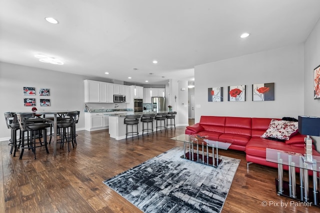 living area with dark wood-style floors, baseboards, and recessed lighting