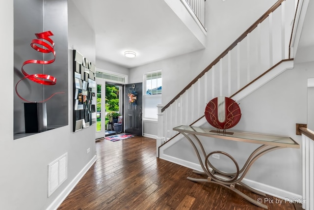 entrance foyer with hardwood / wood-style floors, stairway, visible vents, and baseboards