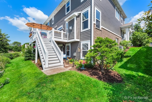 back of house featuring a wooden deck, stairs, and a yard