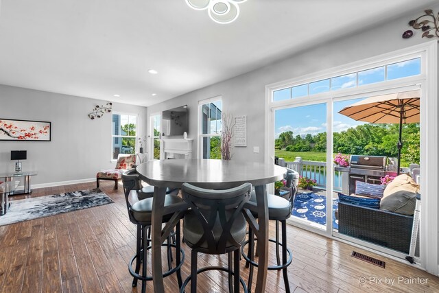 dining space featuring hardwood / wood-style floors, recessed lighting, visible vents, and baseboards