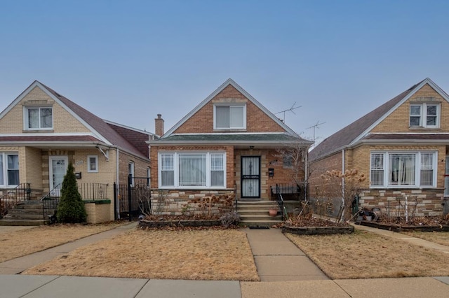 bungalow-style home with stone siding and brick siding