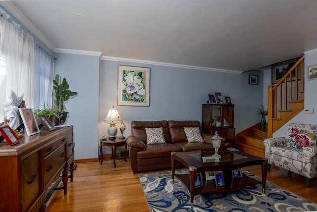 living room featuring light wood-type flooring, stairs, baseboards, and crown molding