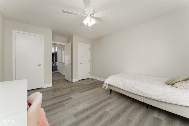 bedroom featuring light wood finished floors, a ceiling fan, and baseboards