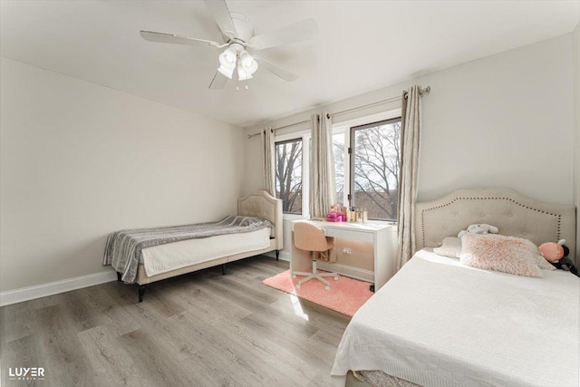 bedroom with ceiling fan, wood finished floors, and baseboards