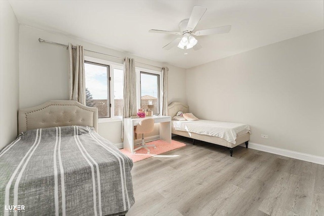 bedroom featuring ceiling fan, baseboards, and wood finished floors