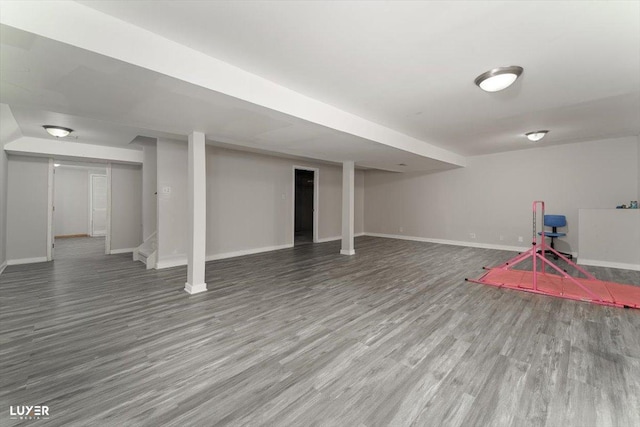 finished basement featuring stairs, baseboards, and wood finished floors