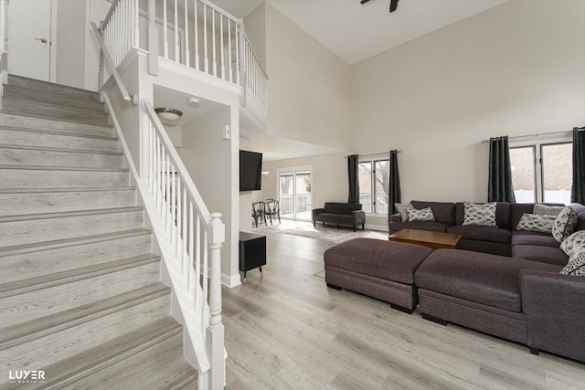 living room featuring stairs, a high ceiling, and wood finished floors