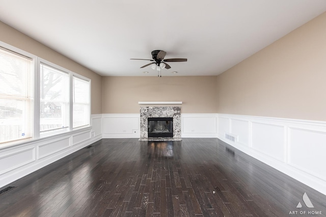 unfurnished living room featuring a fireplace with flush hearth, visible vents, dark wood-type flooring, and a ceiling fan