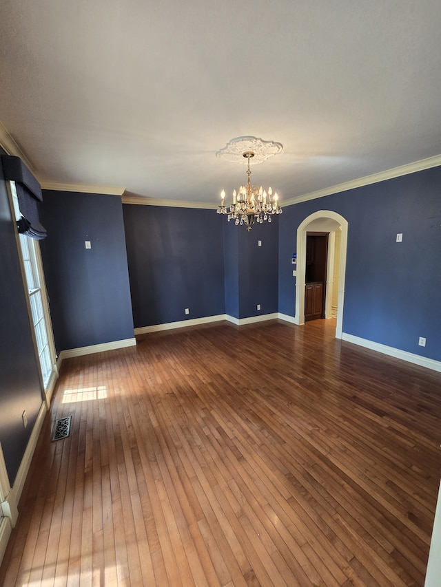 unfurnished room with baseboards, visible vents, ornamental molding, hardwood / wood-style floors, and a notable chandelier