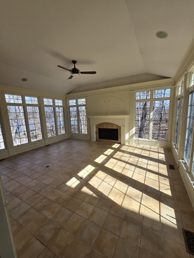 unfurnished living room featuring lofted ceiling, a fireplace, visible vents, and tile patterned floors