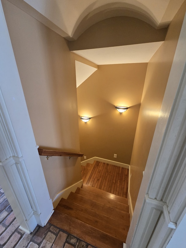 stairs with wood finished floors and baseboards