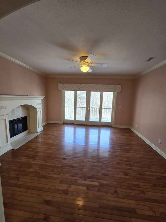 unfurnished living room featuring visible vents, a premium fireplace, ornamental molding, and dark wood finished floors