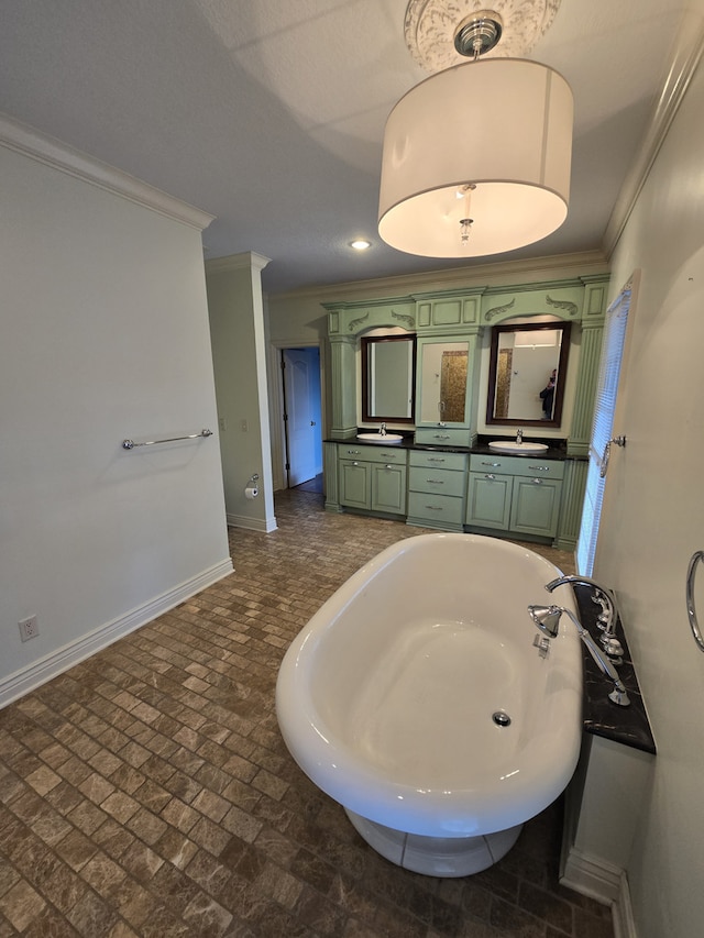 bathroom with crown molding, a washtub, a sink, and baseboards