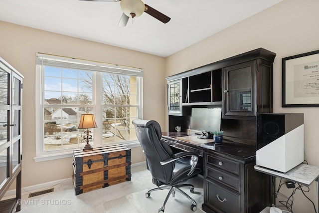 office featuring carpet floors, ceiling fan, visible vents, and baseboards