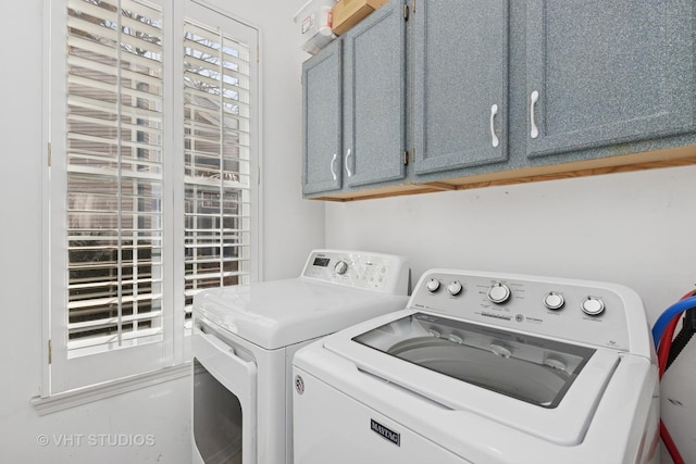 laundry area featuring washer and clothes dryer and cabinet space