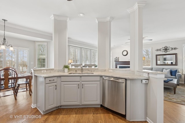 kitchen with open floor plan, dishwasher, light wood-style flooring, and a sink