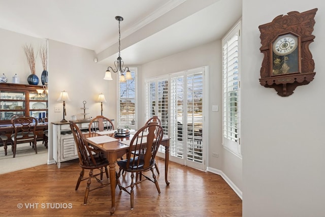 dining room featuring a chandelier, baseboards, and wood finished floors