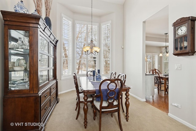 dining area with light carpet, baseboards, and a notable chandelier