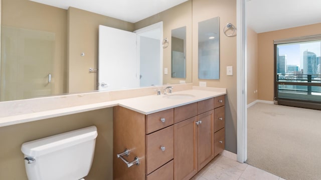 bathroom with toilet, vanity, and baseboards