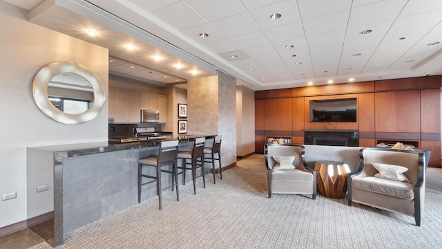 living room featuring recessed lighting, light carpet, a fireplace, and baseboards