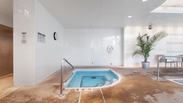 view of swimming pool with an indoor hot tub