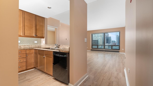 kitchen featuring brown cabinets, light wood-style flooring, backsplash, a sink, and dishwasher