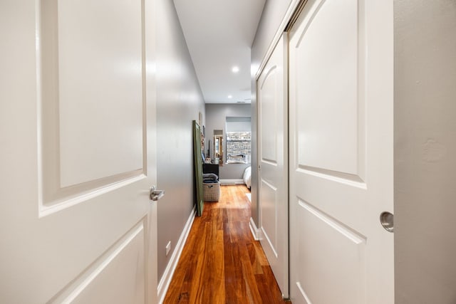 hall featuring recessed lighting, baseboards, and wood finished floors