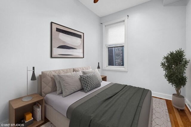 bedroom featuring wood finished floors, baseboards, and ceiling fan