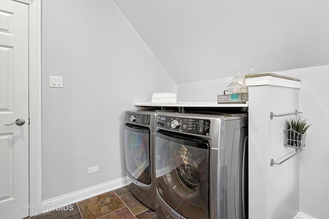 clothes washing area featuring laundry area, independent washer and dryer, baseboards, and stone finish floor