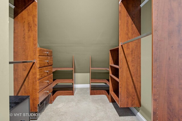 spacious closet with lofted ceiling and carpet