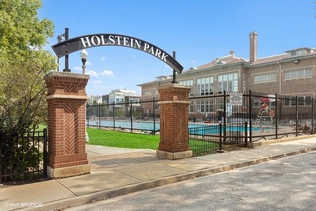 view of property's community with a pool and fence