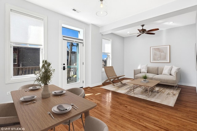 living room with a ceiling fan, wood finished floors, visible vents, and baseboards