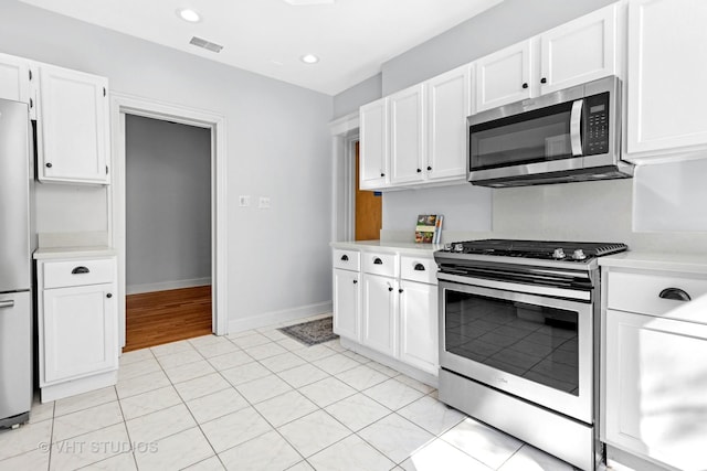 kitchen featuring visible vents, appliances with stainless steel finishes, white cabinetry, and light countertops