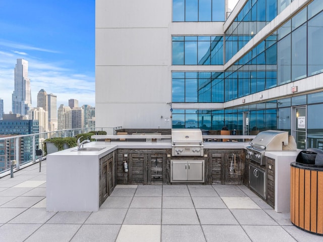 view of patio featuring area for grilling, a grill, a view of city, and a sink