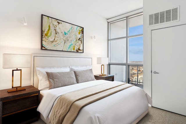 bedroom featuring visible vents, carpet floors, and expansive windows