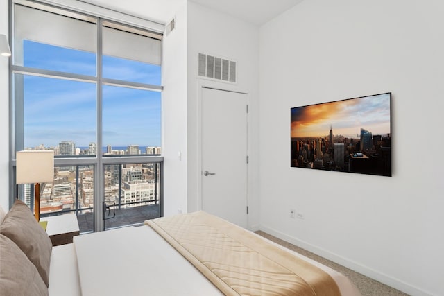 bedroom featuring visible vents, floor to ceiling windows, carpet flooring, and baseboards