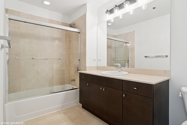 full bath featuring combined bath / shower with glass door, toilet, vanity, and tile patterned floors