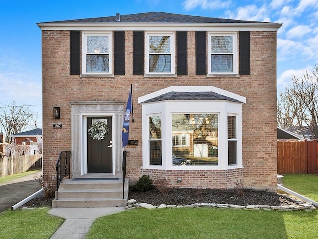 view of front of house with fence and brick siding